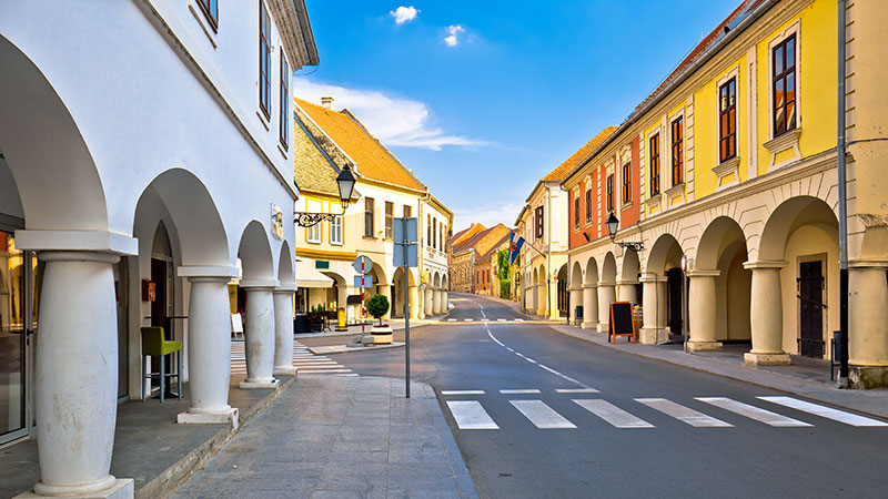 En vei gjennom byen Vukovar med stilfulle bygninger p hver side.