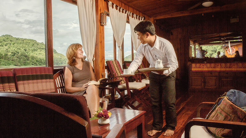 Dame som blir servert en kopp te av en hyggelig ansatt