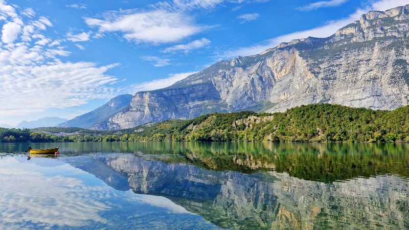 Fjellsider reflekteres i den klare Cavedinesj�en