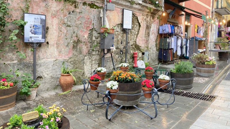 slitt vegg, nydelige blomsterkasser p bakken , en klesbutikk med klesstativ utenfor butikken