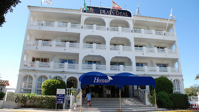 Inngang til Club Playa Real. Stor hvitt hotell. 
