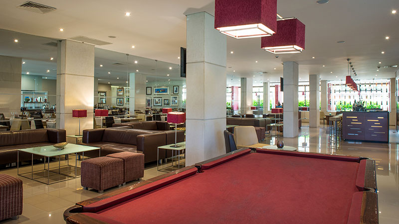 Builjardbord foran stoler og bord i en bar