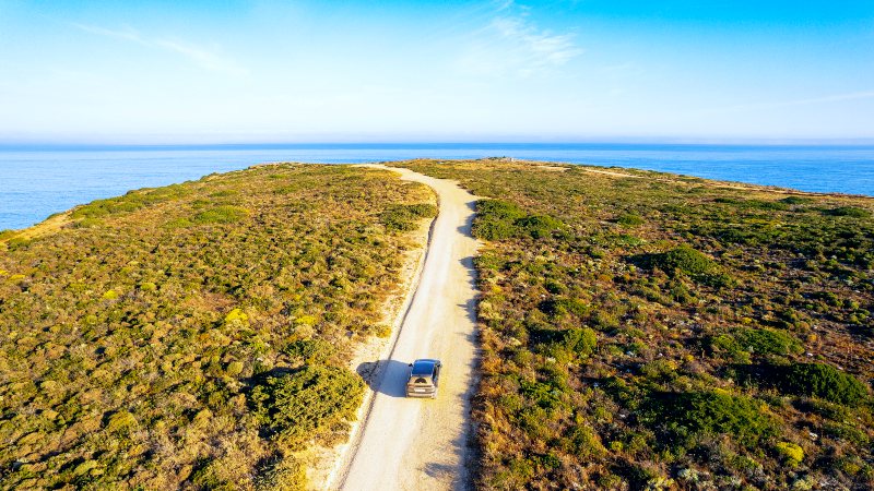 Bil kjrer mot havet p grusvei
