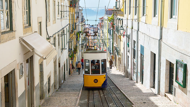 En tripp på vei opp trange gater i Lisboa.